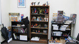 La collection de jouets d'Arkayne est fièrement exposée dans son bureau. La collection de jouets d'Arkayne est fièrement exposée dans son bureau.